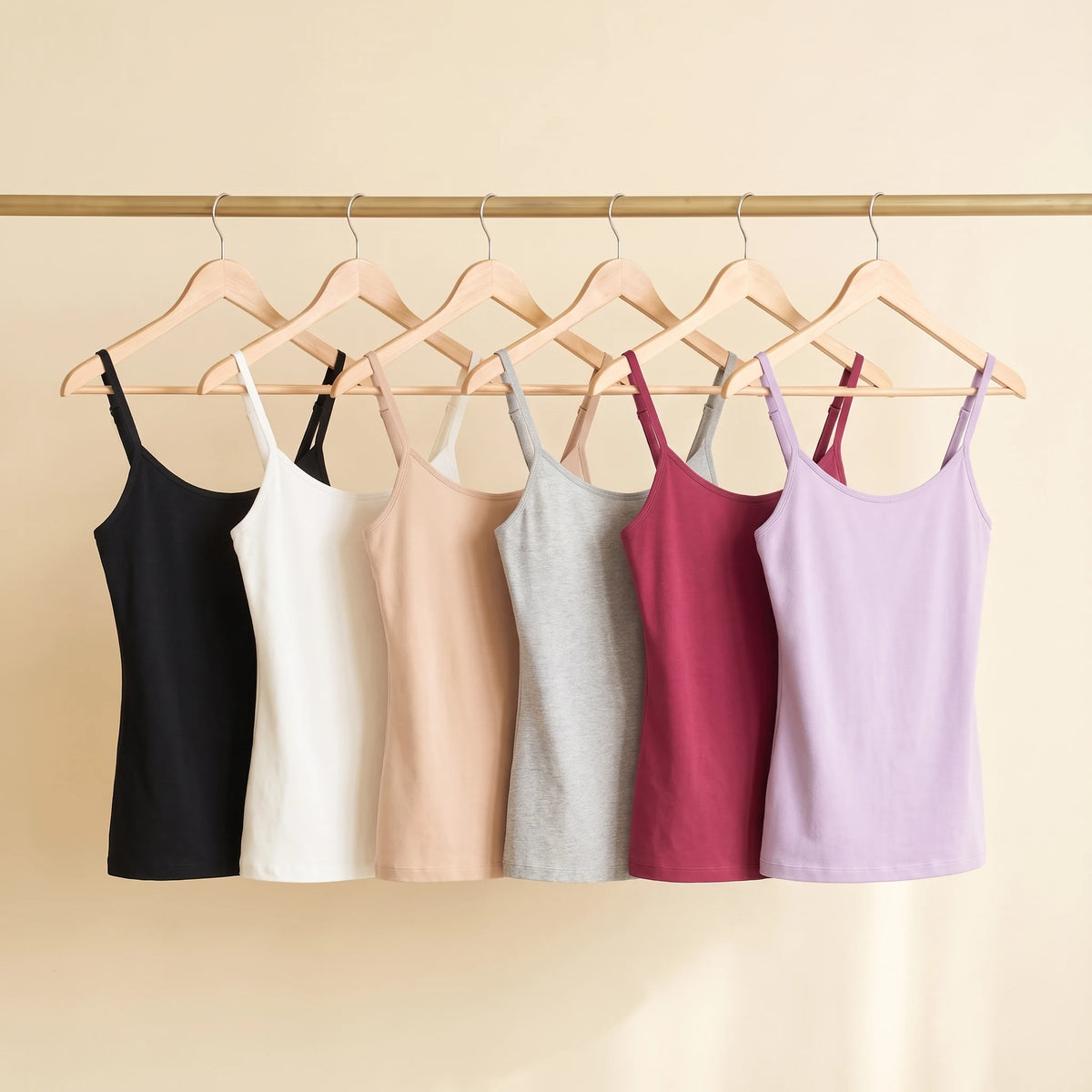 All six Kischt Aurelle built-in bra tank top colours on a rail: black, white, beige, grey, burgundy and lavender