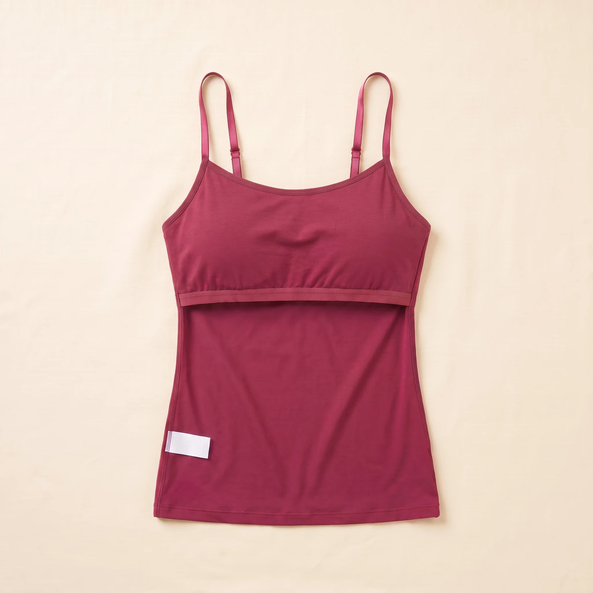 Inside of the Cerise burgundy Kischt Aurelle tank top, turned inside out: the built-in shelf bra is fully covered by a smooth fabric lining with a soft elastic band