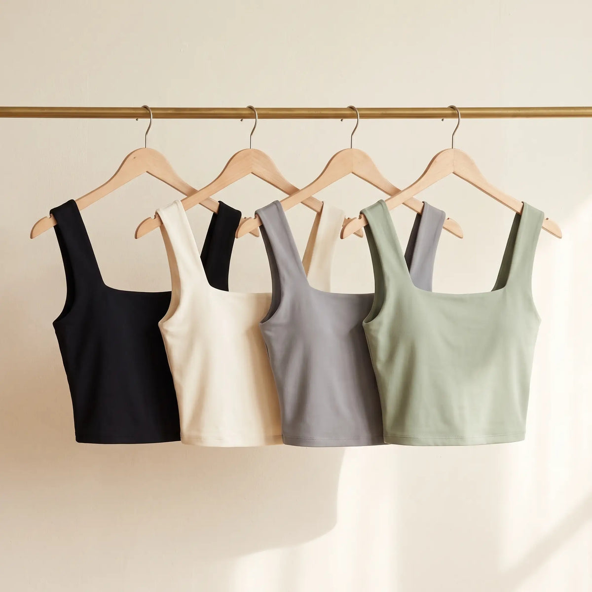 All four Kischt Elodie square neck crop tank colours on a rail: black, ivory, grey and sage green
