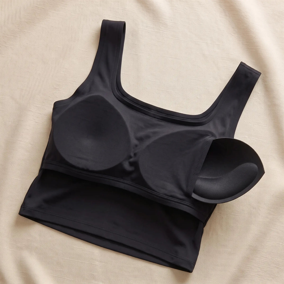 Inside of the Noir black Kischt Elodie crop tank: a built-in bra lining with soft removable pads, no underwire