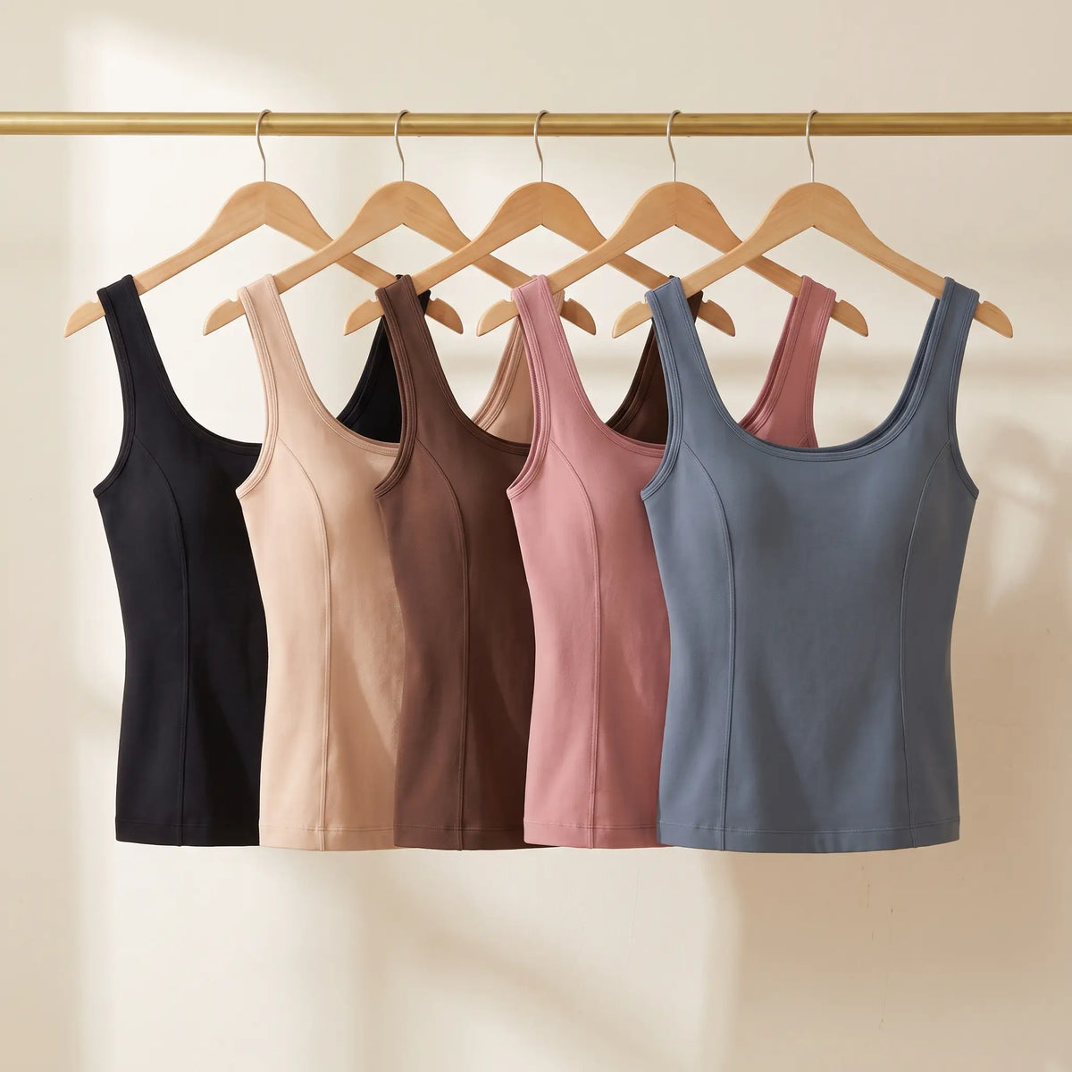 All five Kischt Estelle seamless built-in bra tank top colours on a rail: black, beige, brown, dusty pink and blue-grey