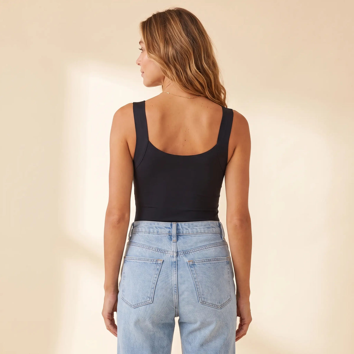Back view of the Noir black Kischt Estelle tank top with wide straps and a smooth scoop back with no bra lines