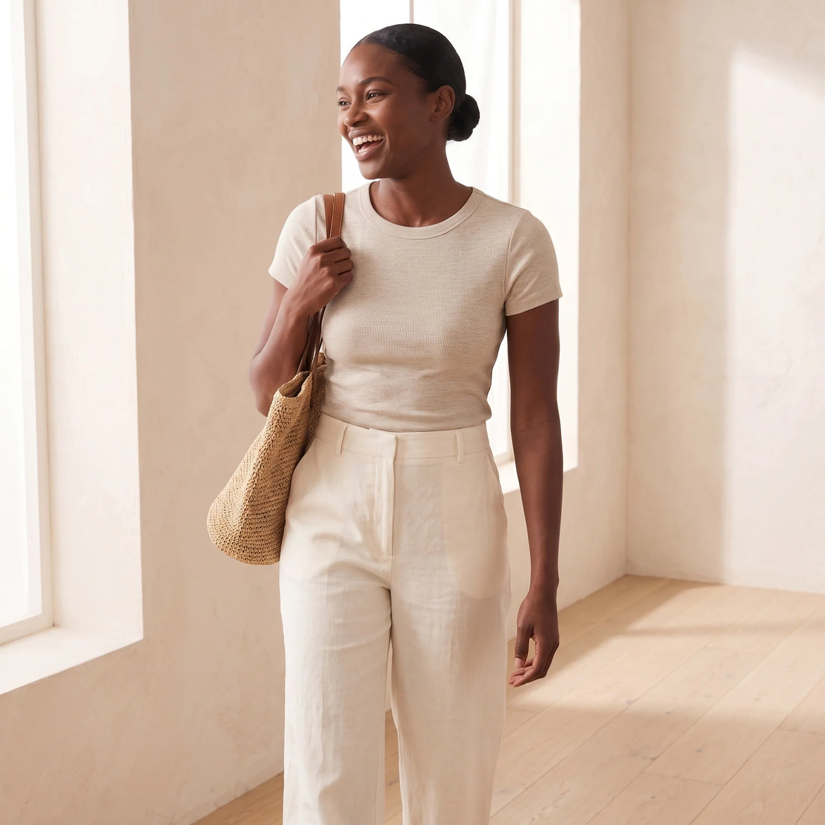 Woman walking with a straw tote in a fitted oat T-shirt over the Blanc white Kischt Juliette plunge bra, with no visible lines