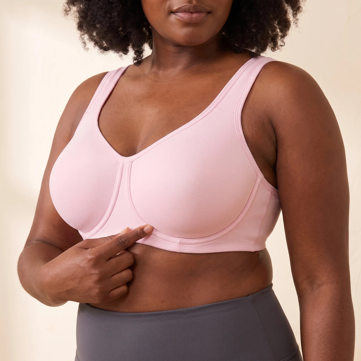 Close-up of the Blush pink Kischt Léonie sports bra showing the underwire sewn on the outside of each full-coverage cup