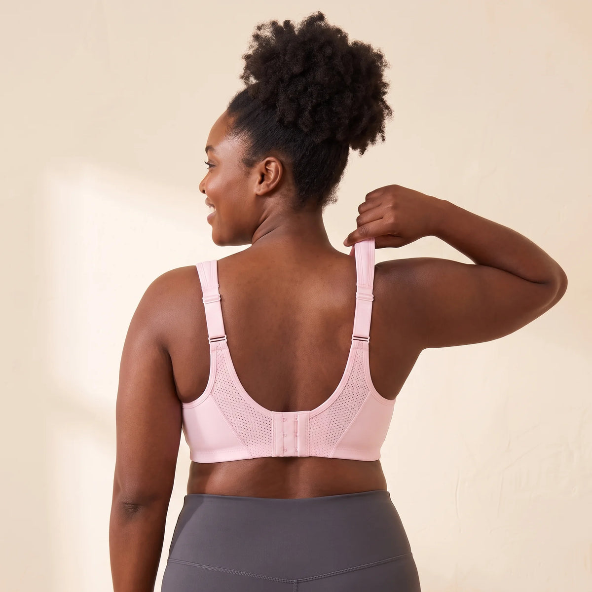 Back view of the Blush pink Kischt Léonie sports bra with wide ladder-adjustable straps, a breathable mesh back and a hook-and-eye closure