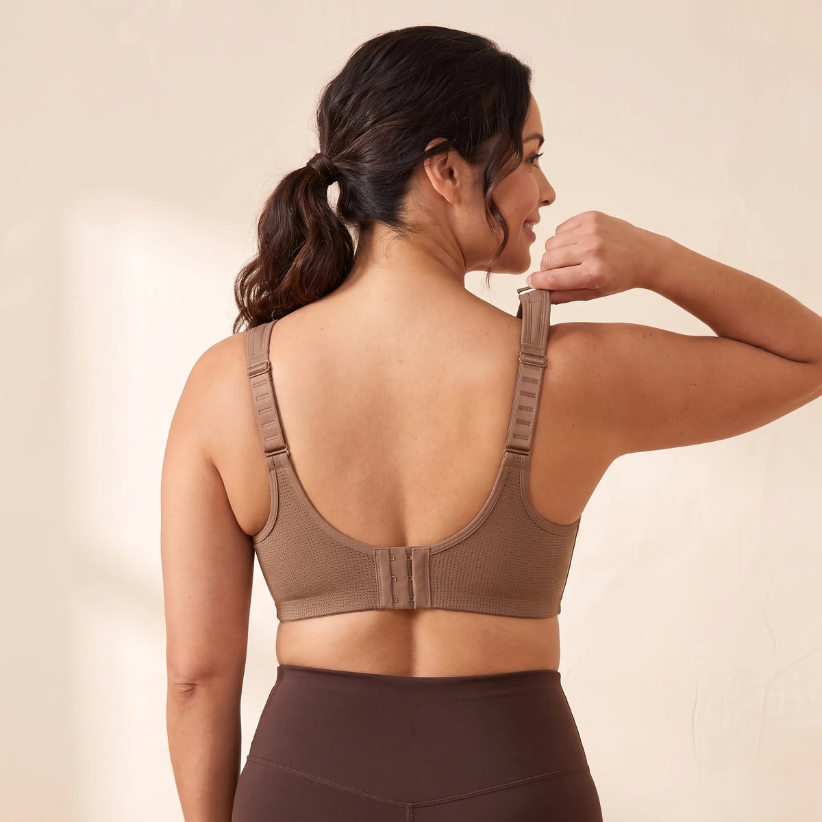 Back view of the Mocha brown Kischt Léonie sports bra with wide ladder-adjustable straps, a breathable mesh back and a hook-and-eye closure