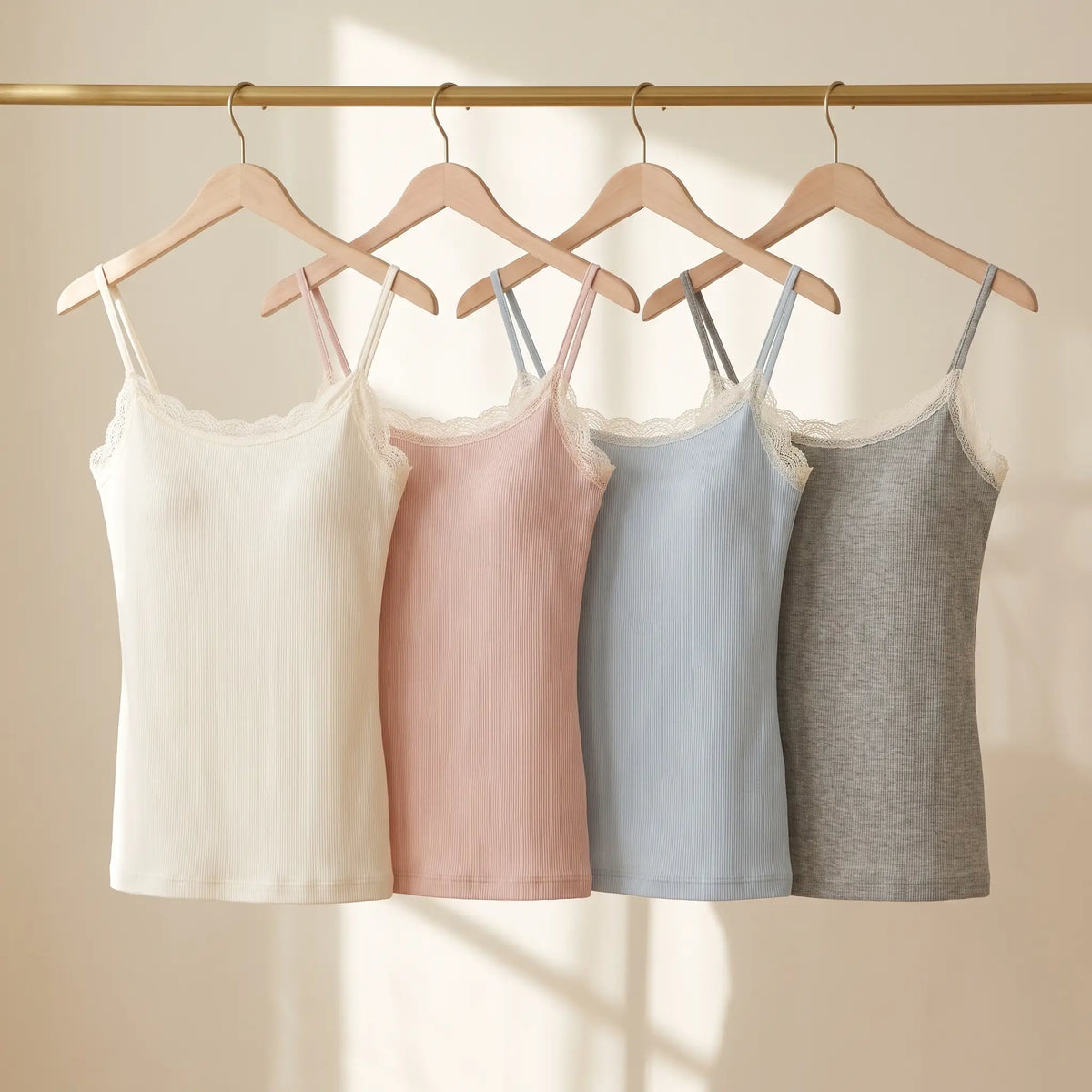All four Kischt Lisette lace trim cami colours on a rail: ivory, blush pink, pale blue and heather grey