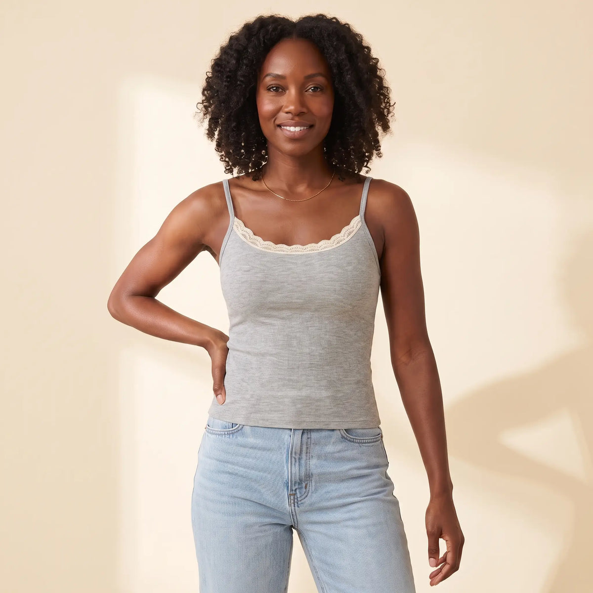 Woman in her 30s wearing the Kischt Lisette lace trim ribbed cami with built-in bra in Gris heather grey with high-waisted jeans