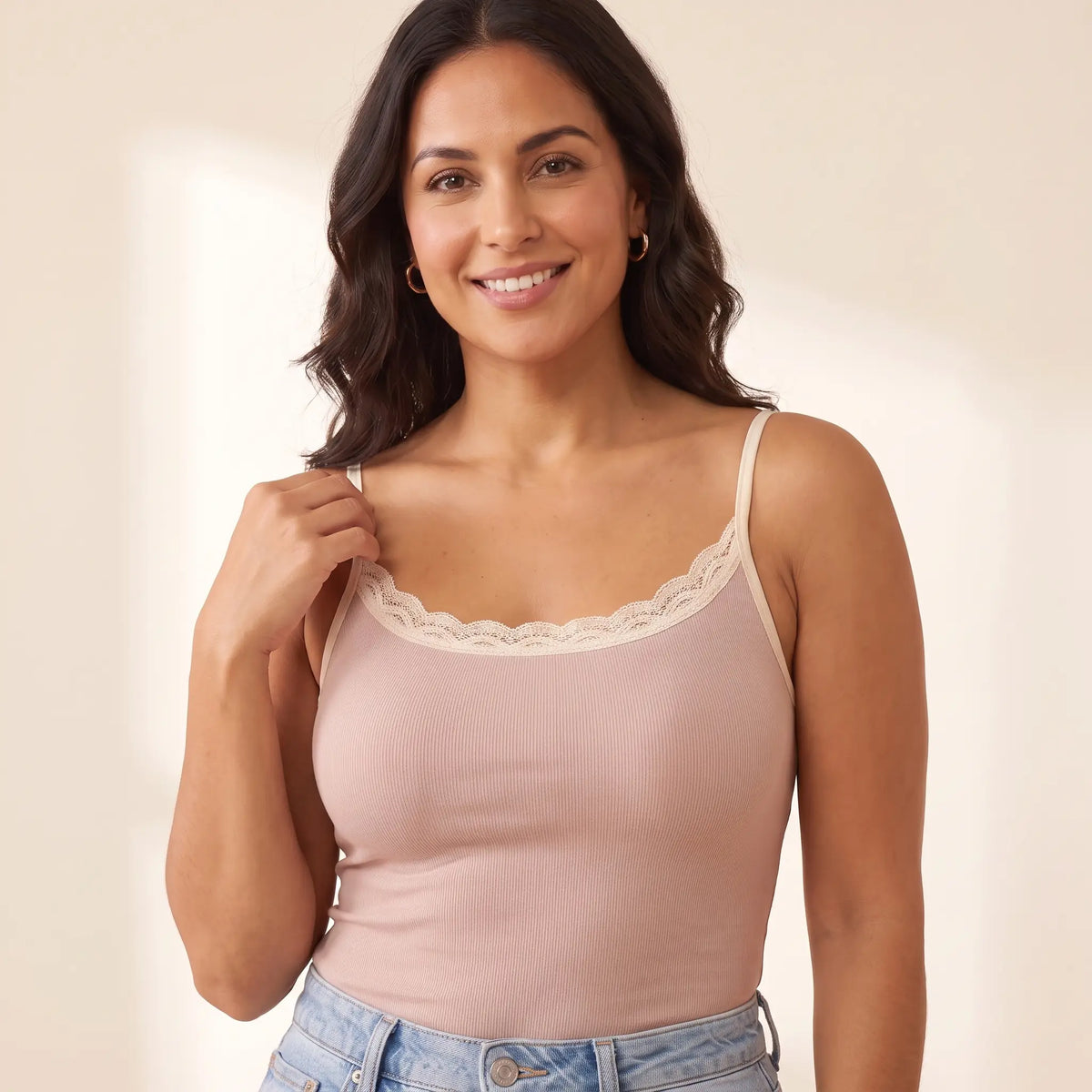 Close-up of the Poudre blush pink Kischt Lisette cami showing the cream lace trim, thin straps and a smooth front with the built-in bra hidden inside