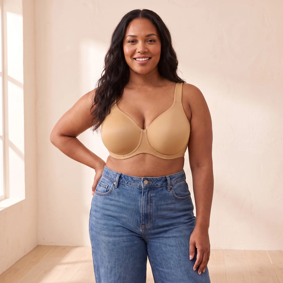 Curvy woman with long dark hair, hand on hip, wearing the Kischt Margaux full coverage unlined minimizer bra in Almond golden tan with jeans