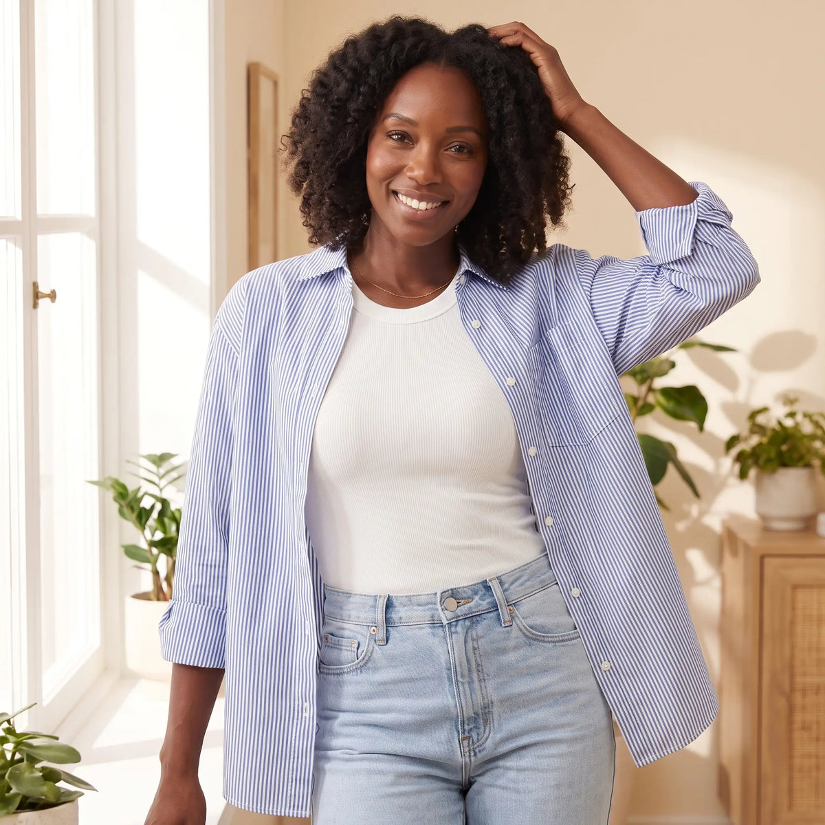 Woman in the Blanc white Kischt Noemi racerback tank top with built-in bra under an open striped shirt with jeans