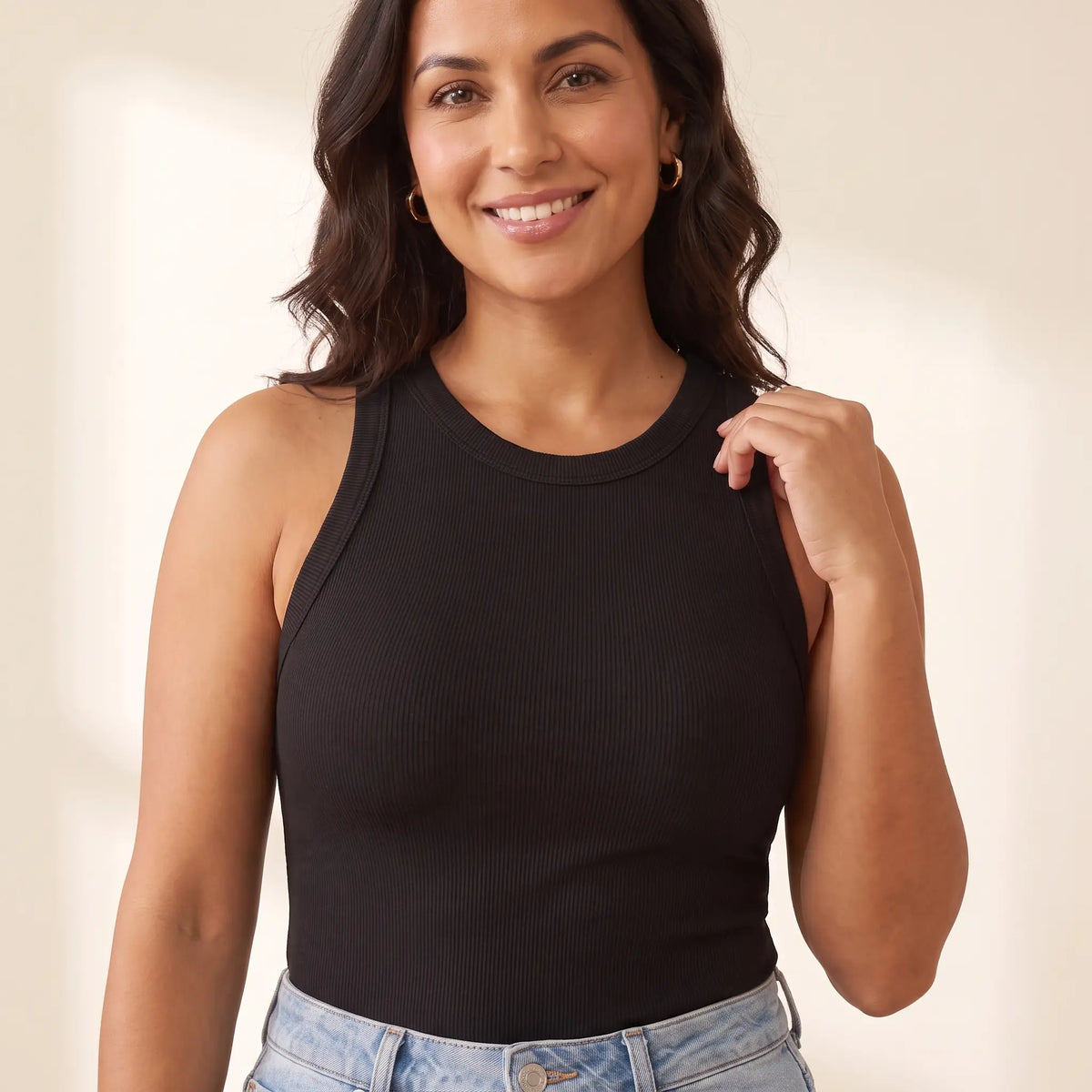 Close-up of the Noir black Kischt Noemi racerback tank top showing the high crew neck and a smooth front with the built-in bra hidden inside