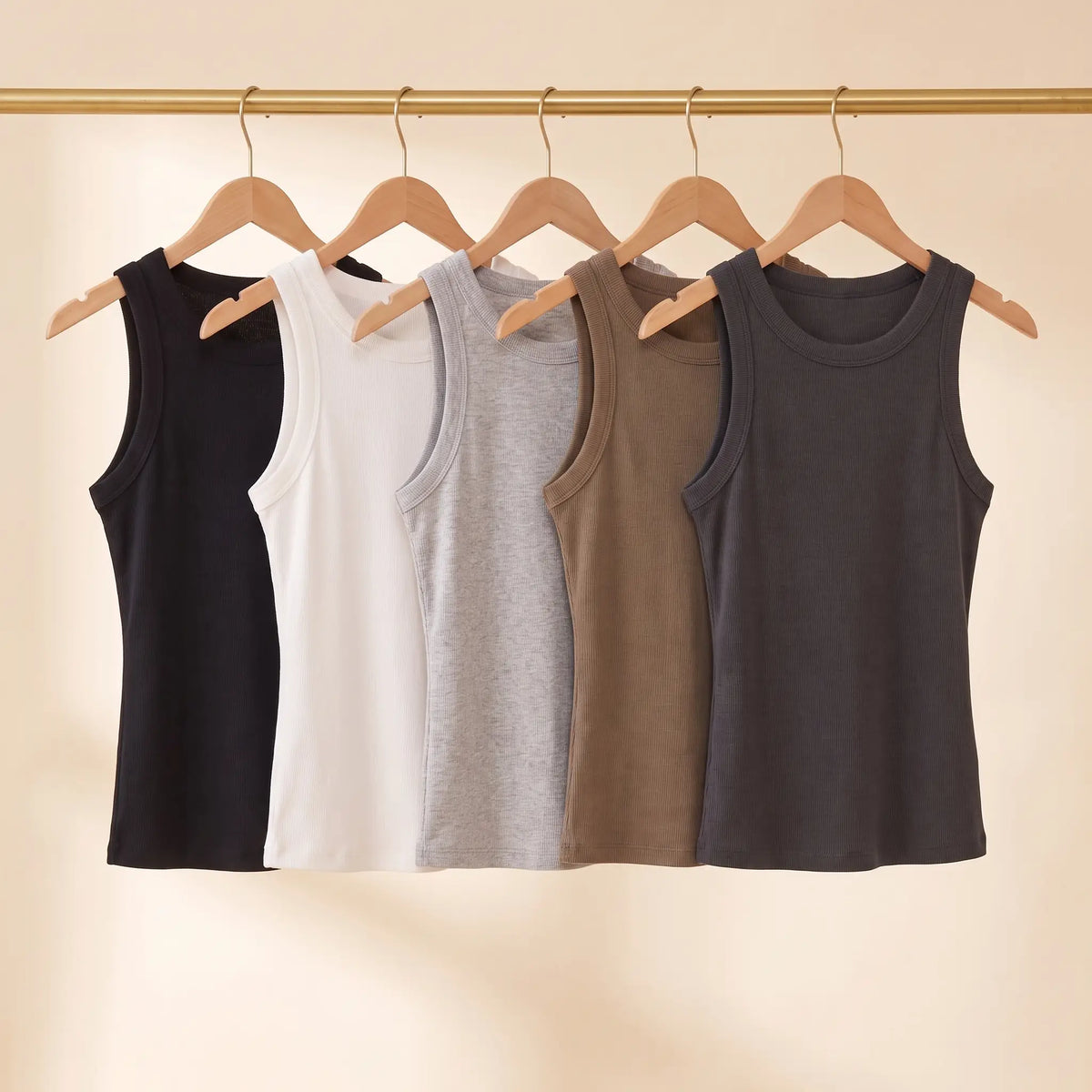 All five Kischt Solene ribbed built-in bra tank top colours on a rail: black, white, light grey, khaki and dark grey