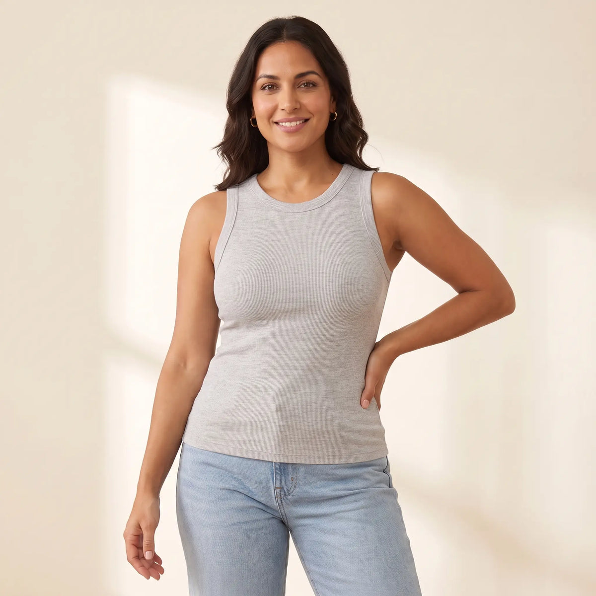 Woman in her 30s wearing the Kischt Solene ribbed crew neck tank top with built-in bra in Brume light grey with high-waisted jeans