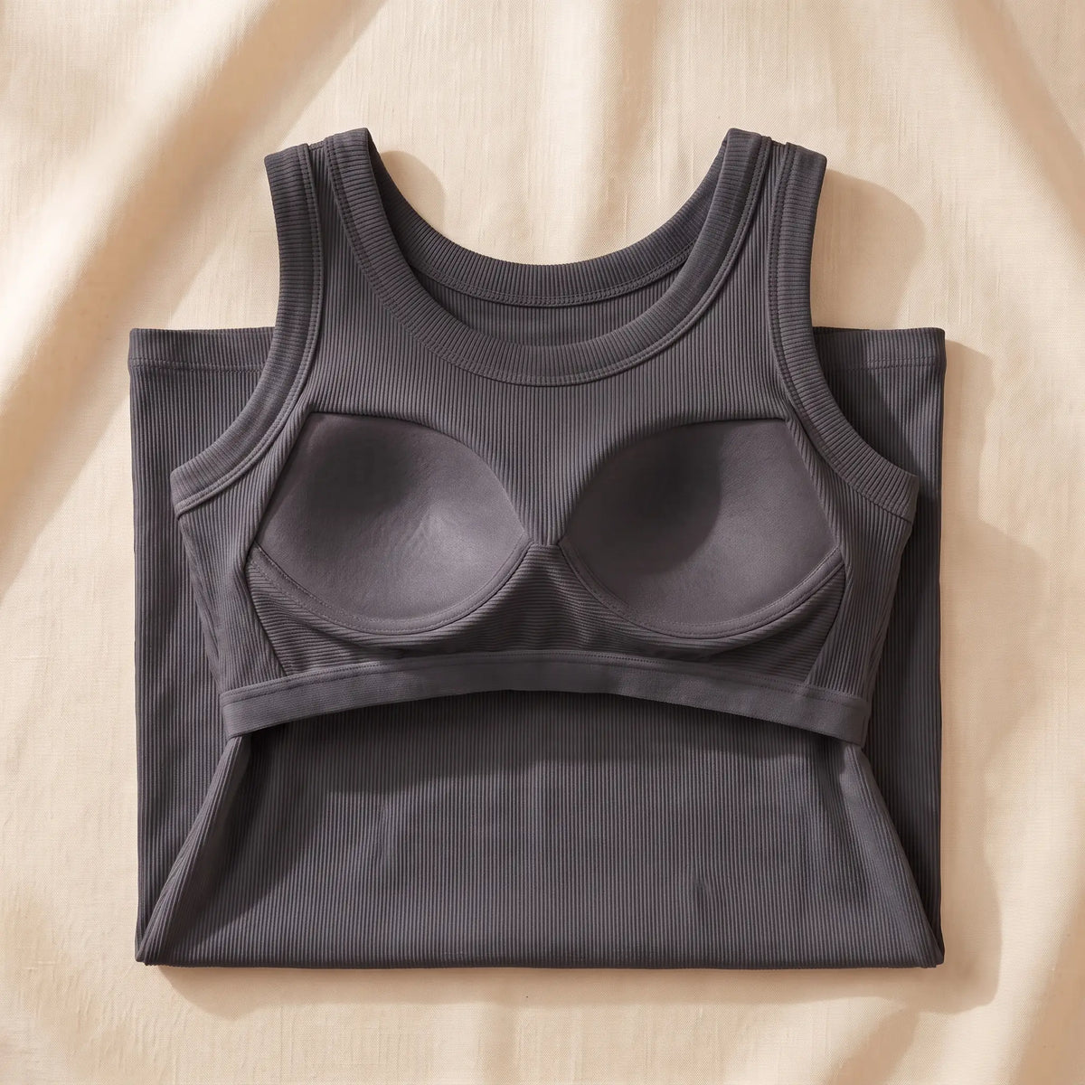 Inside of the Graphite dark grey Kischt Solene ribbed tank top: a built-in shelf bra with soft padded cups on an elastic underbust band, no underwire