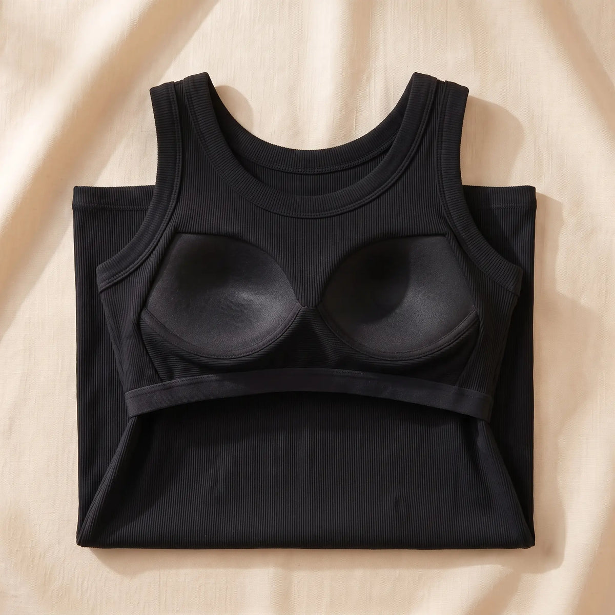 Inside of the Noir black Kischt Solene ribbed tank top: a built-in shelf bra with soft padded cups on an elastic underbust band, no underwire